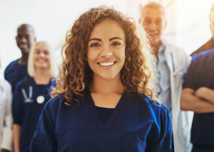 Smiling female doctor standing with medical colleagues in a hosp